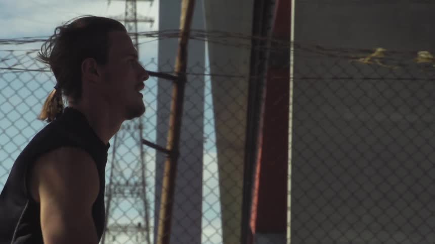 Man running beside a fence
