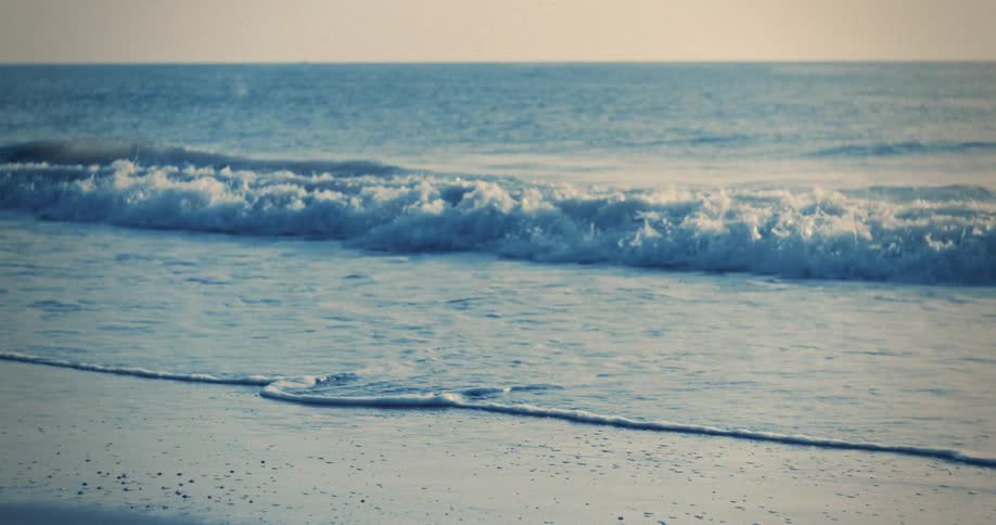 The small waves move over the sand