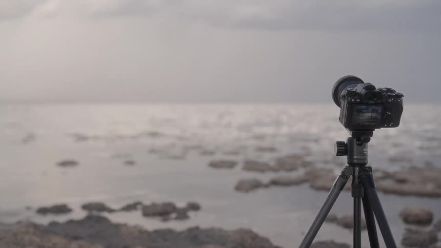 The camera is on a tripod by the shore