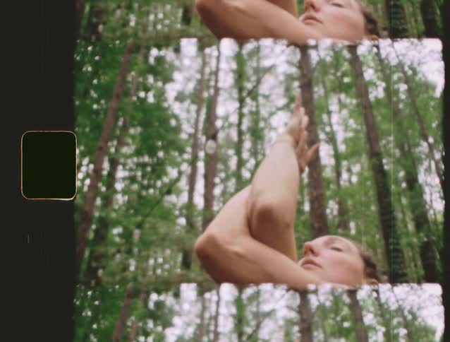 This is a stylized shot with a vertical splitscreen effect showing three overlapping staggered views of the same scene the scene features a persons face and armshoulder raised against a backdrop of a dense forest or wooded area with a n