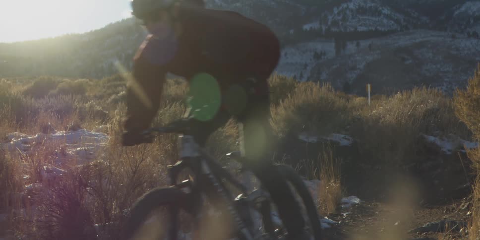 A man rides his mountain bike through the desert brush in the mountains