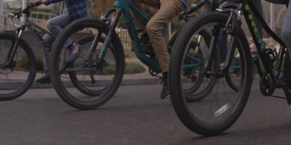 A group of people is riding bikes on the street through a neighborhood
