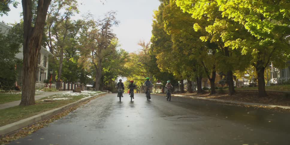 Four children riding bicycles through the city streets