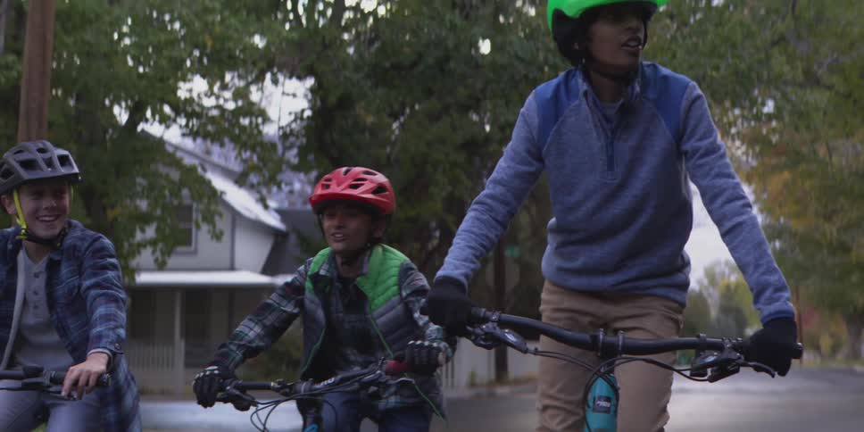 The children talk while riding their bikes