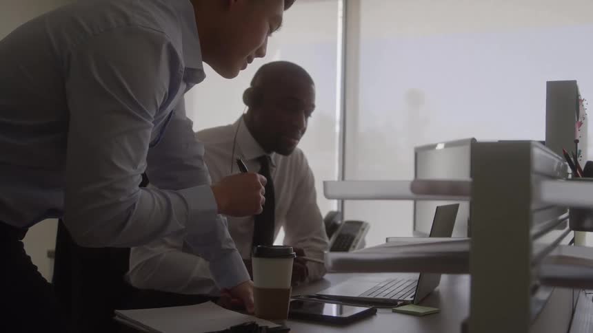 Coworkers working in an office consult during the daytime