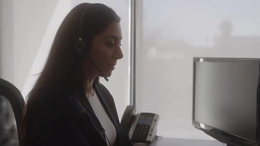 Woman types on a laptop while working in an office