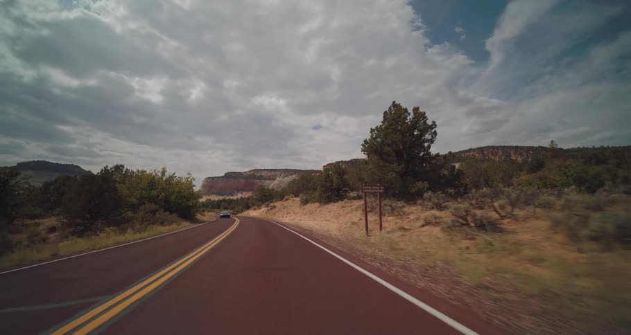 The car drives down the winding highway