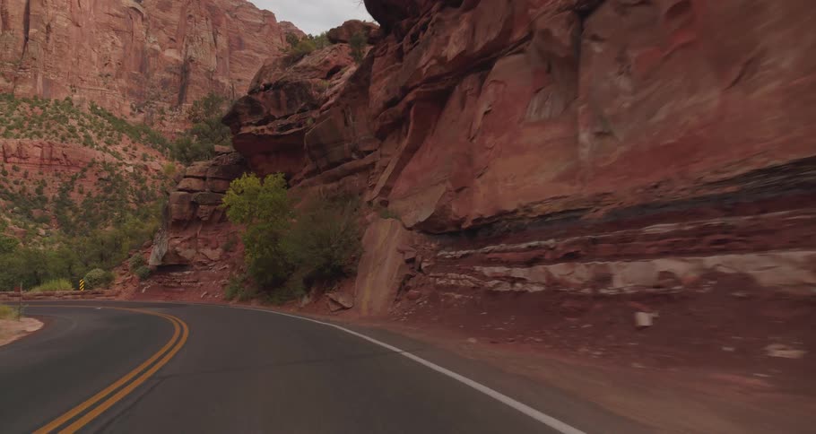 Winding road between reddish rock formations