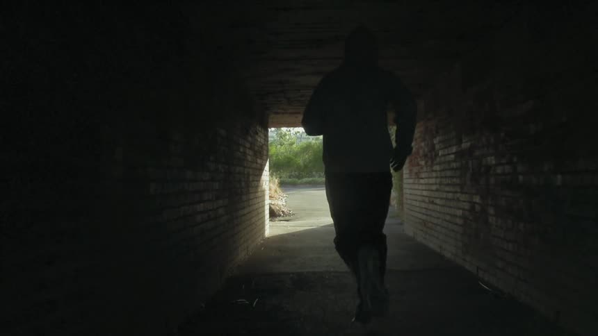Man running down a small tunnel