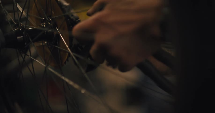 Close up of a man hands as he works on the gears of a bicycle