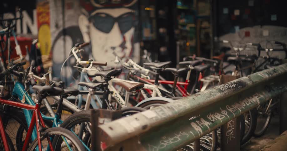 Bicycles parked in an urban area with a graffiti mural in the background