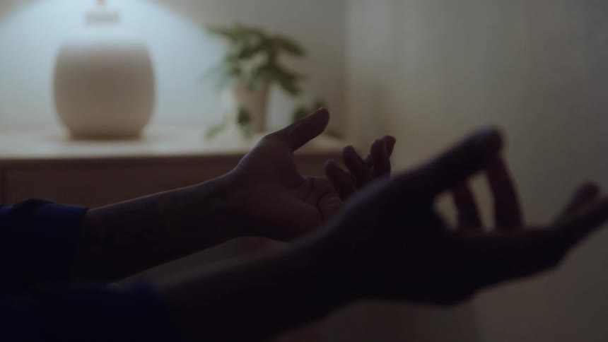 The man puts his hands out while meditating