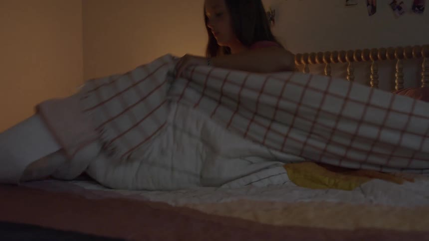 A girl climbs into bed