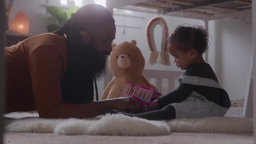 The father talks with his daughter as they play with toys