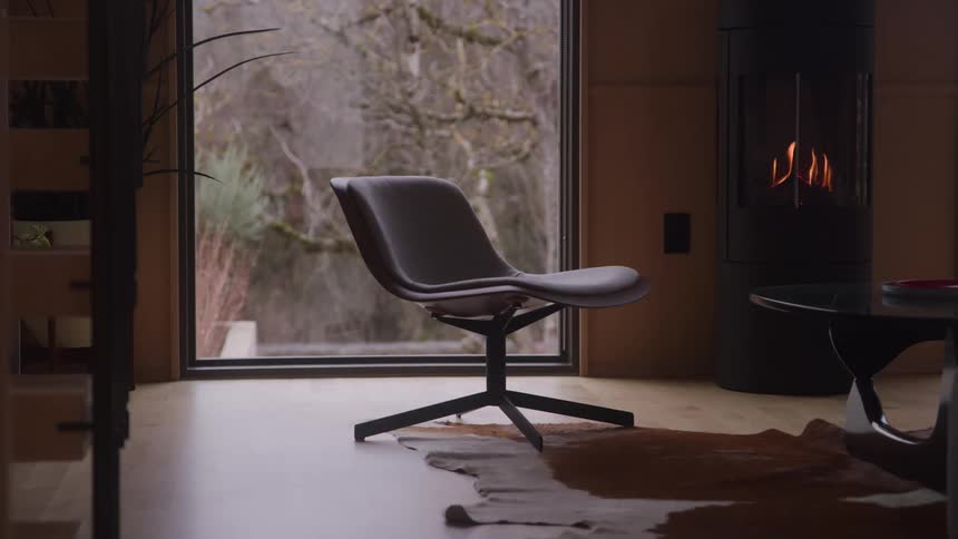 Chair near a window as flames flicker in the fireplace