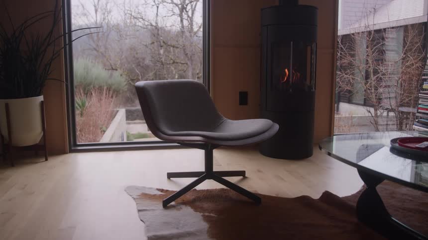 Chair near a window as flames flicker in the fireplace