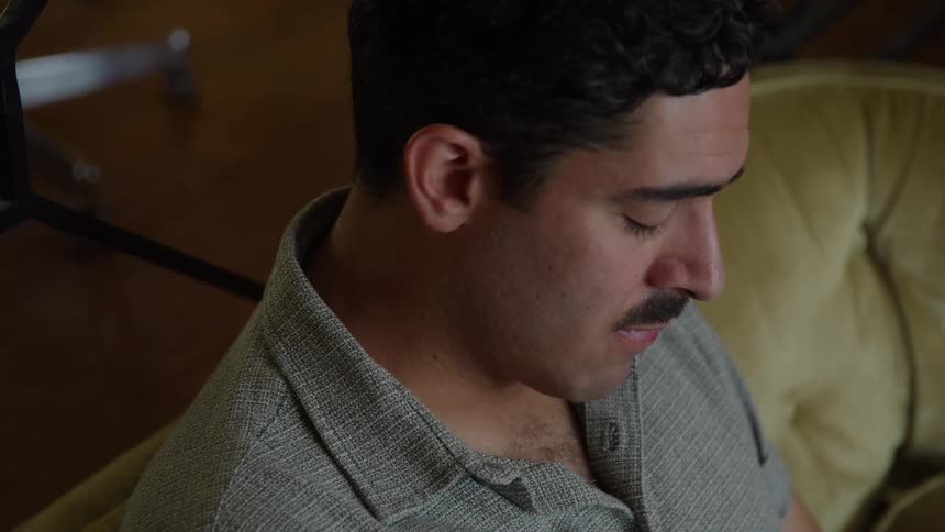 Man sitting on a couch looking sad