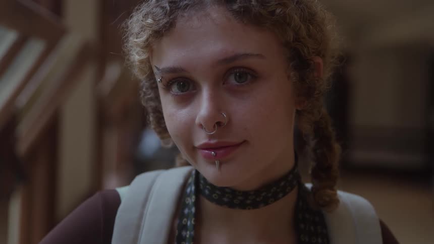 Close up portrait of a young woman standing in a room during daytime