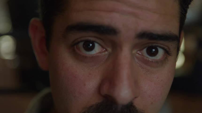 Hispanic young man with a nervous face expression indoors during day time