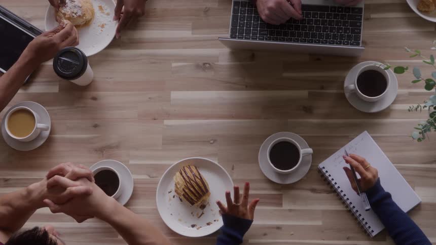 People have pastries and coffee together at the table