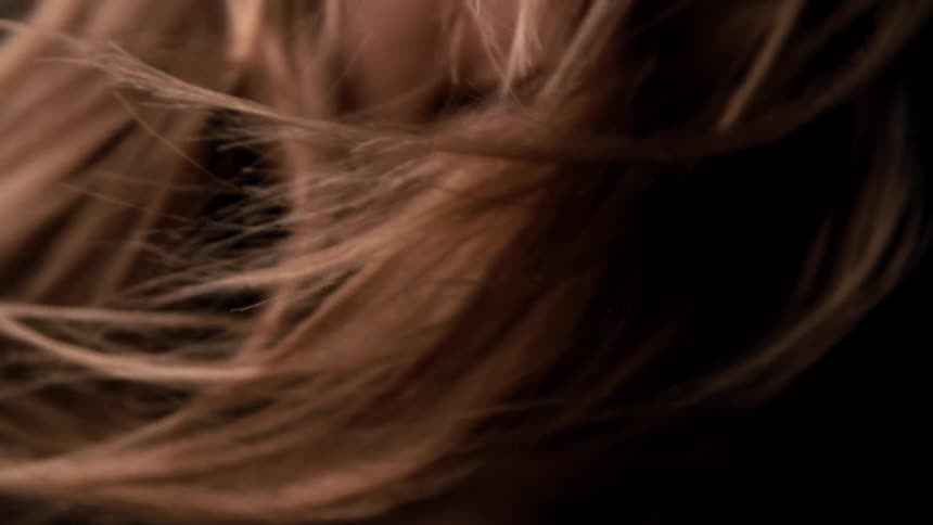 The womans blonde hair blows in the wind