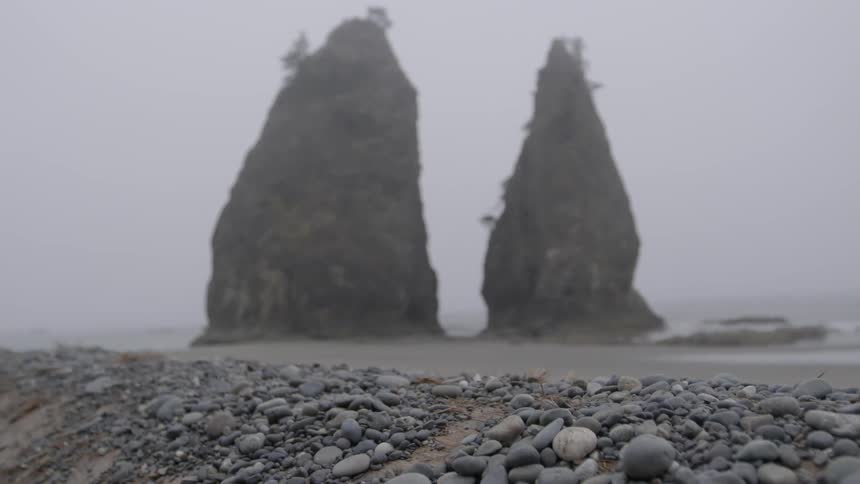 Two tall rocks sit by the water