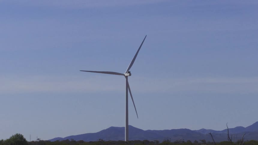 The car drives past the windmill