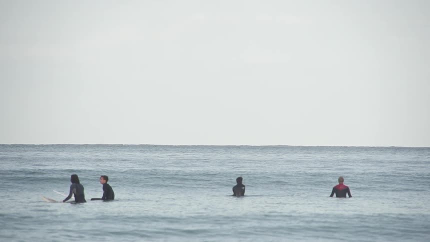 Surfers floating on their boards out in the ocean