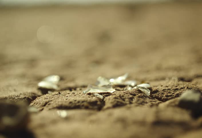 Shards of broken glass on the ground outdoors during daytime