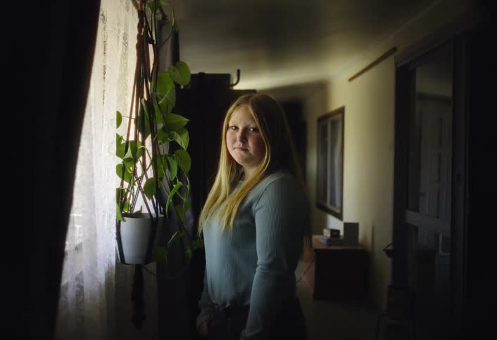 Portrait of a young woman standing in a corridor during daytime