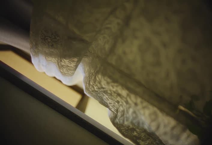 A curtain moves slightly in the breeze
