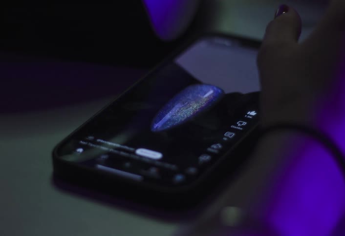 Close up of a young woman scrolling and watching social media videos on a mobile phone
