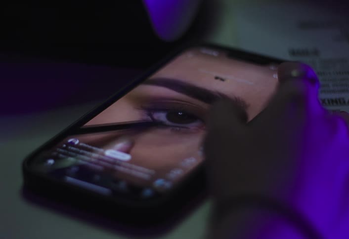 The woman watching a makeup tutorial video presses thumbs up on the phone screen