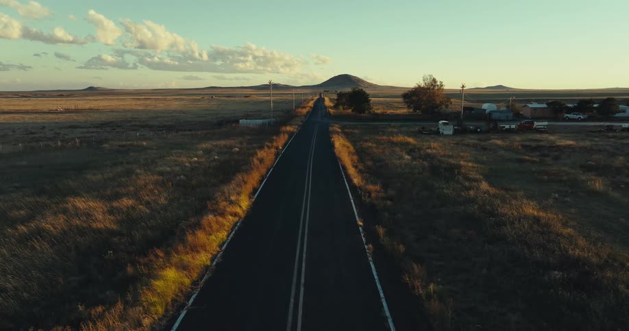 Aerial of a rural highway in the plains at sunset