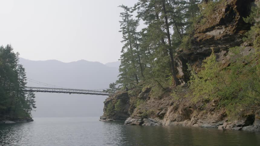 Walking bridge crossing over mountain lake