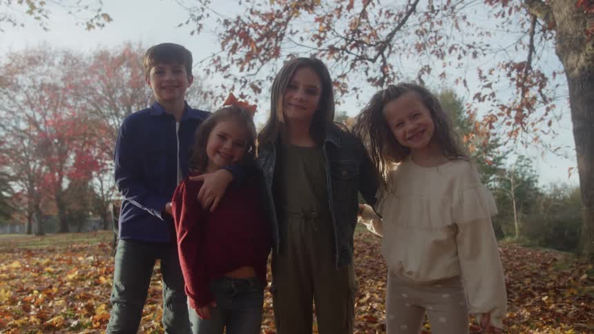 A group of kids outdoors near some trees