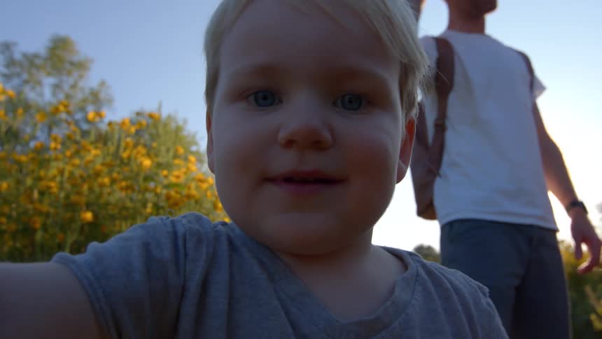 Child smiles in a flower field at sunset
