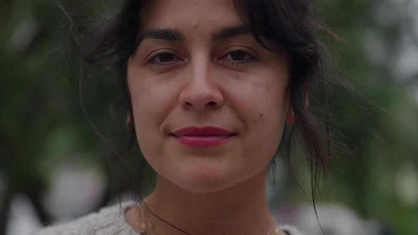 Close up portrait of a young woman standing outdoors during daytime