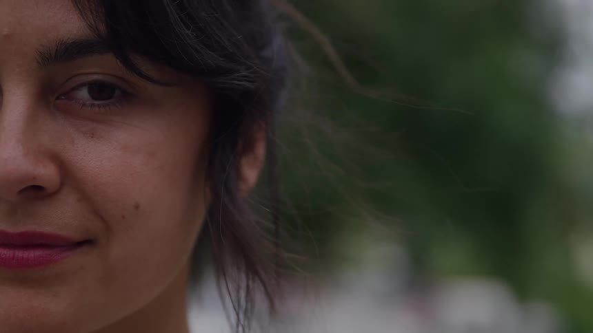 Half of the face of a hispanic young woman outdoors