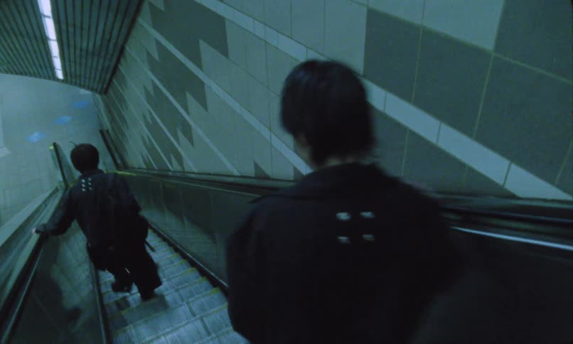 Two people run down the escalator