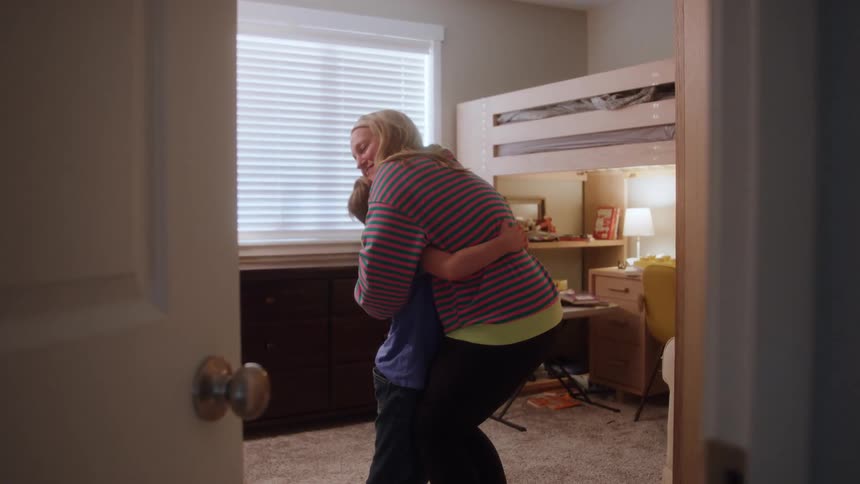 Mother and son hug while in the childs bedroom