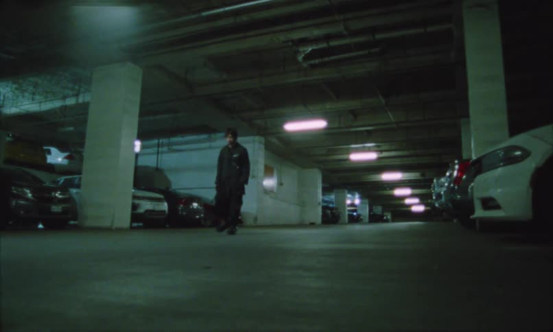 The man walks through the parking garage