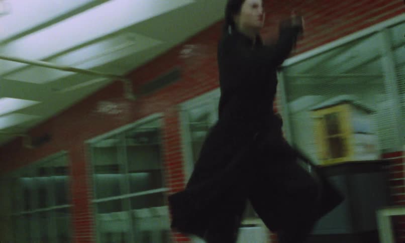 A person with a bag is being chased by another person through a station