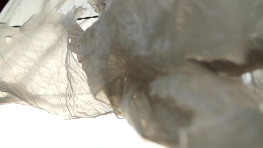 Plastic wrapped in a fence blows around