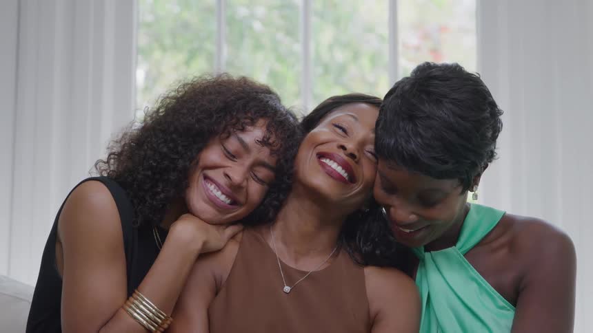 Three happy women close together smiling and embracing each other