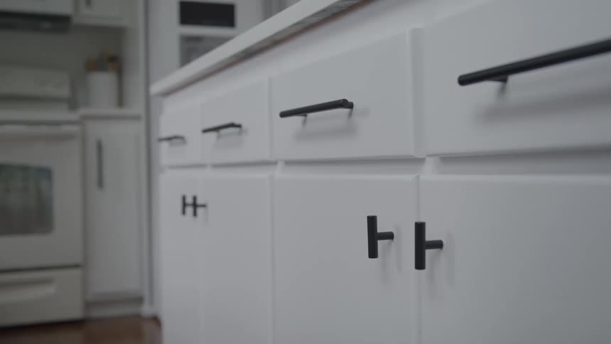 The kitchen has white cabinets