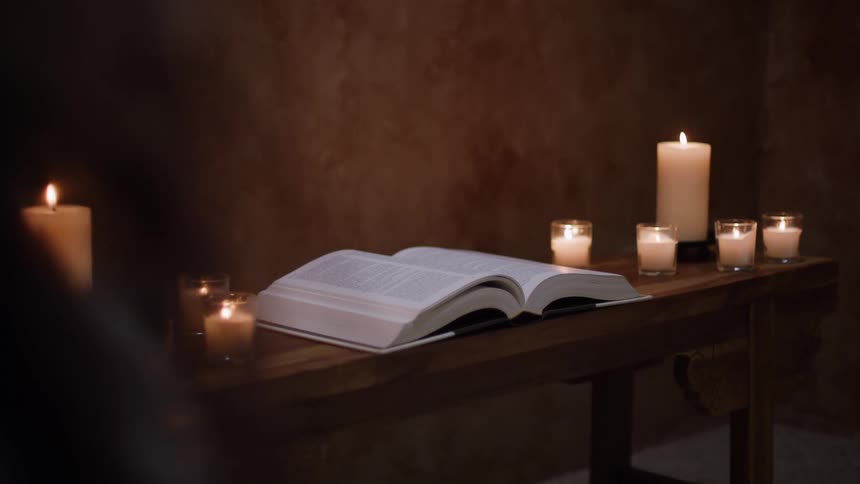 A book on a table with candles