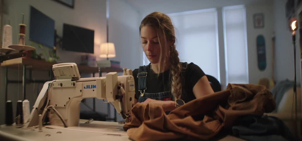 A woman sewing clothes in a room