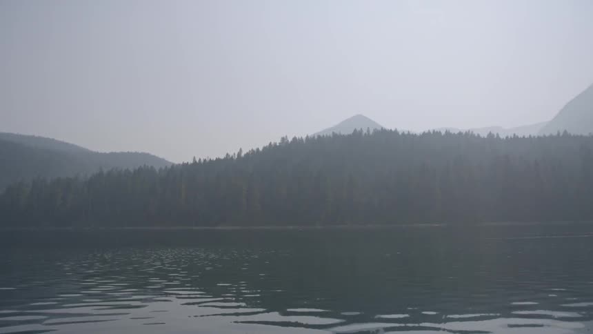 The water is calm in this lake before a mountain