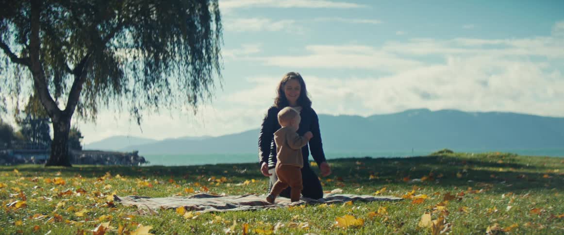 The woman lays down the picnic blanket in the park